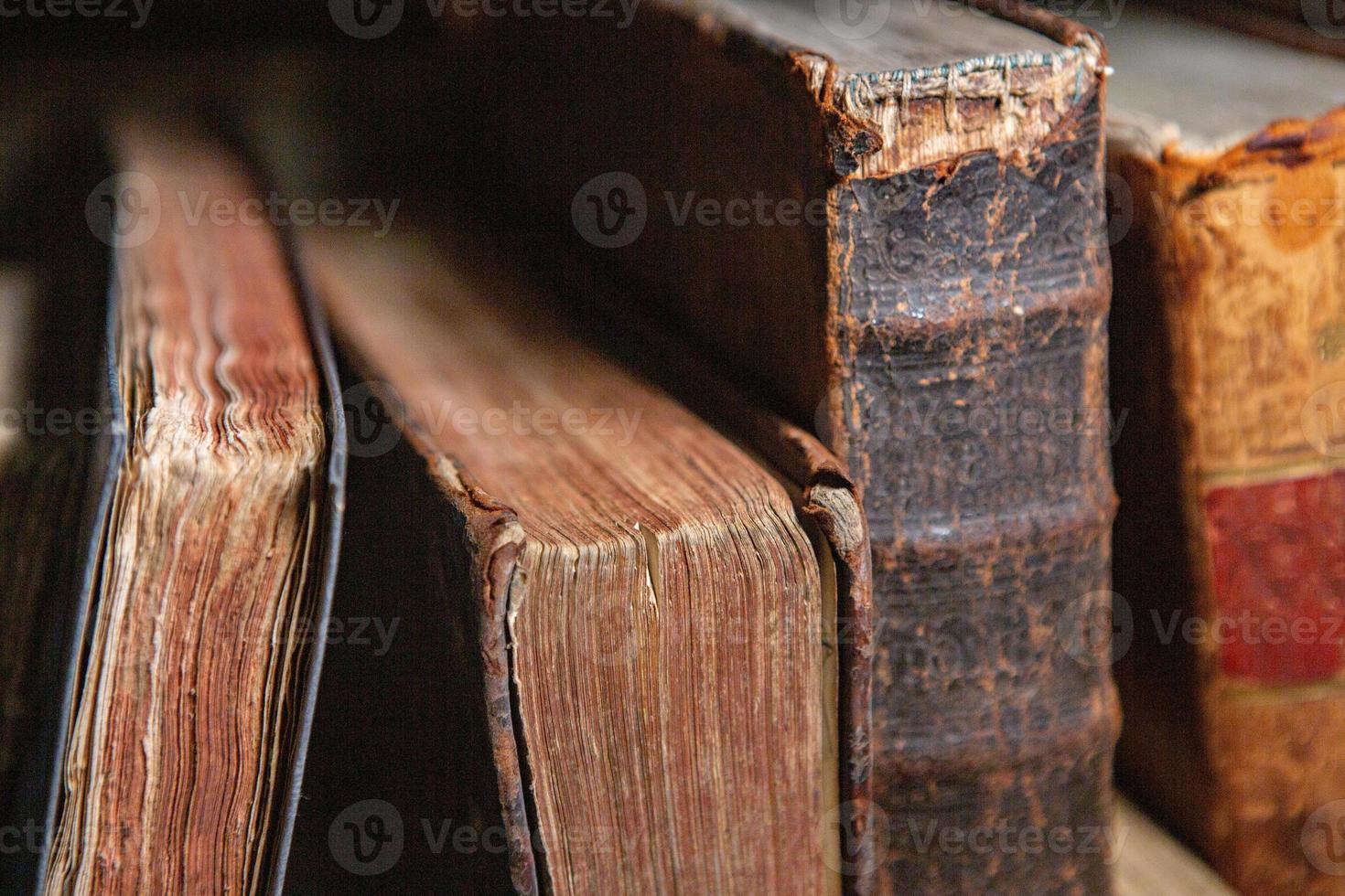 Very old books sitting on the shelves in the library. Books as a symbol of knowledge. photo