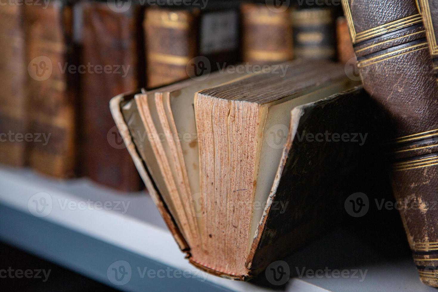 Very old books sitting on the shelves in the library. Books as a symbol of knowledge. photo