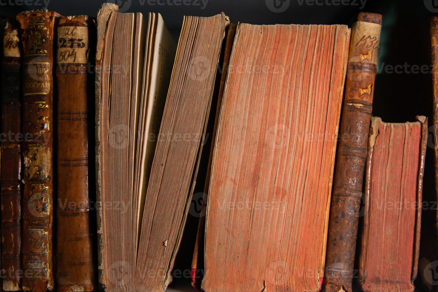 Very old books sitting on the shelves in the library. Books as a symbol of knowledge. photo