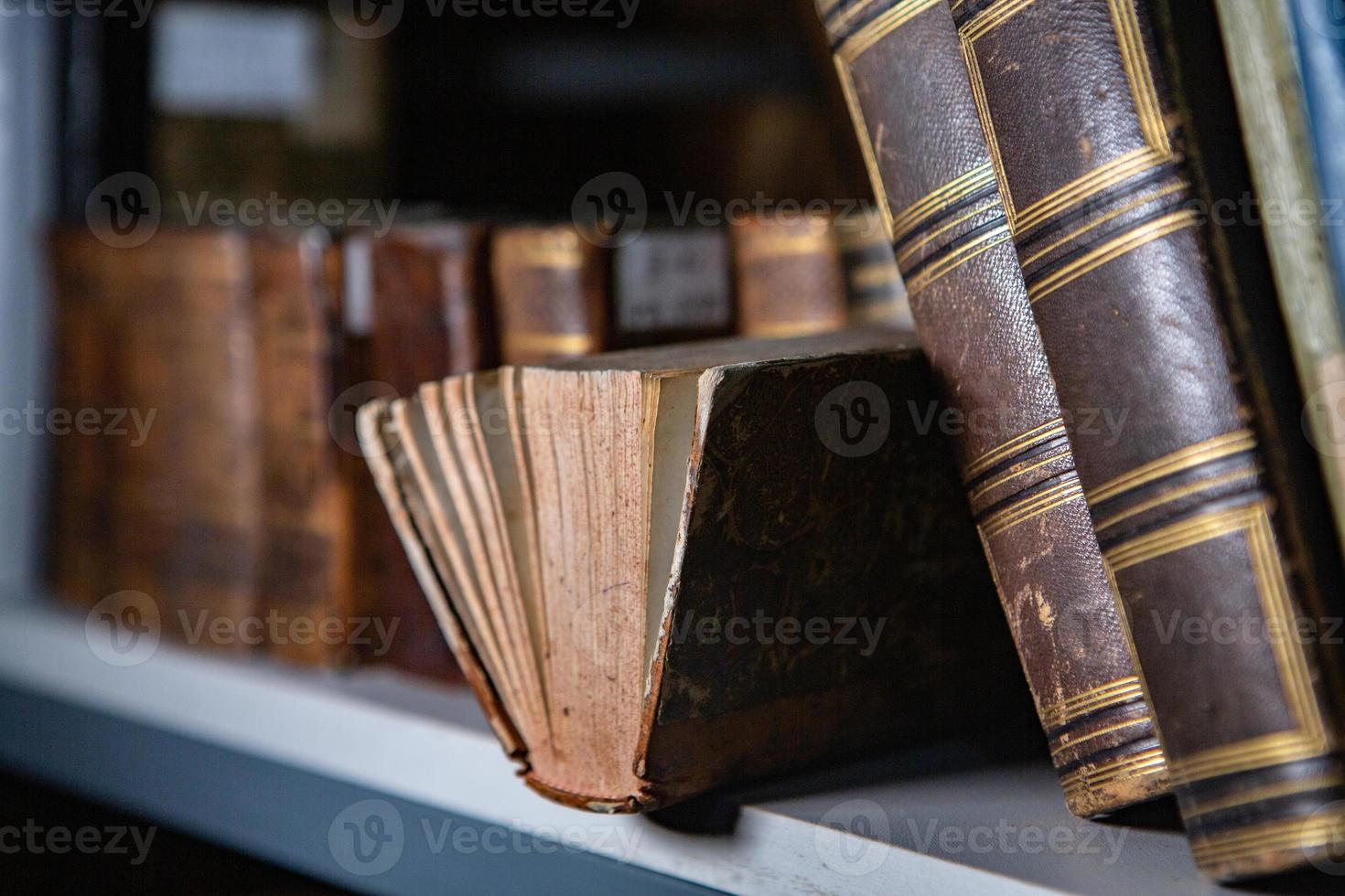 Very old books sitting on the shelves in the library. Books as a symbol of knowledge. photo
