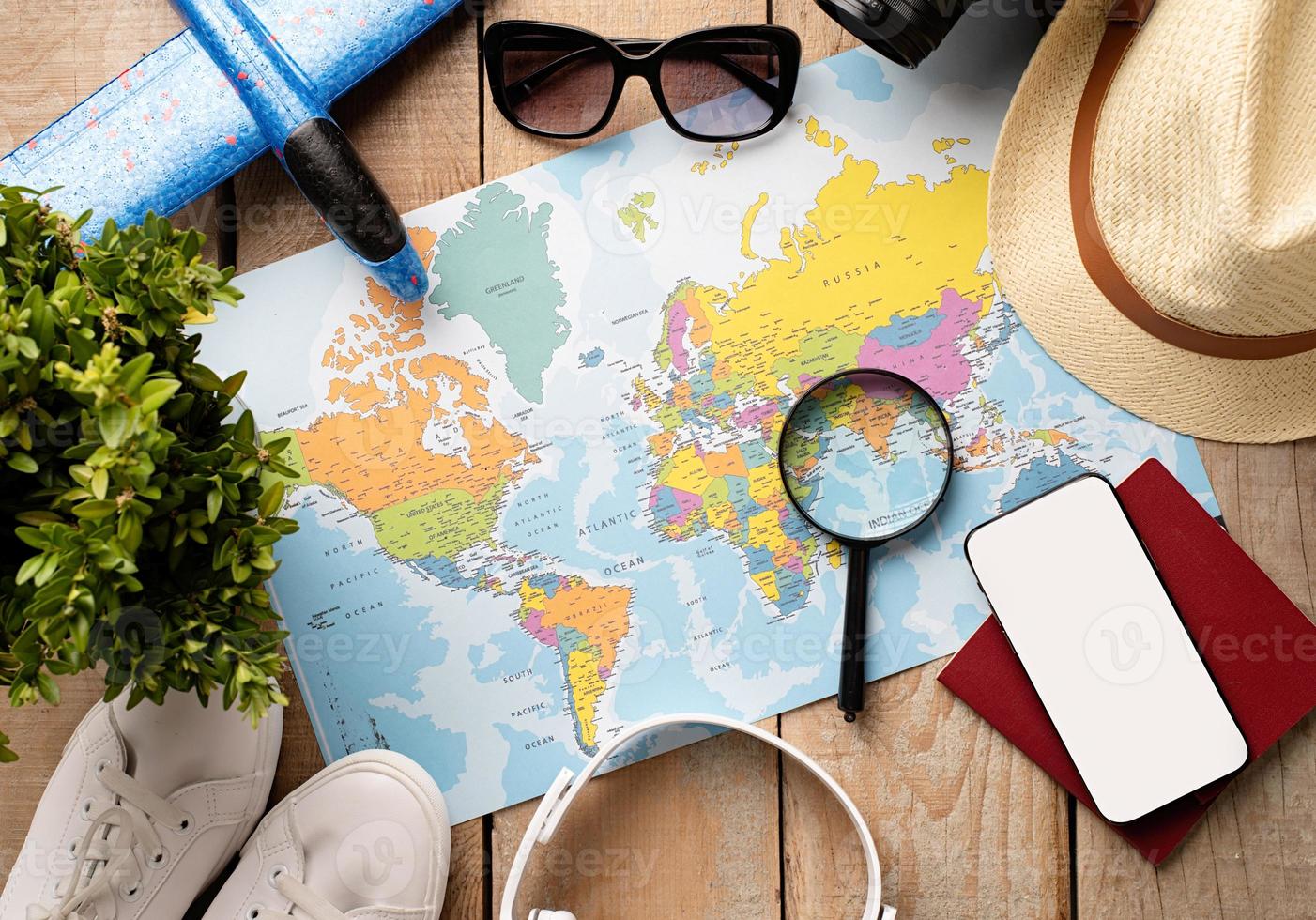 Flat lay traveler accessories on map, camera, glasses, digital devices photo