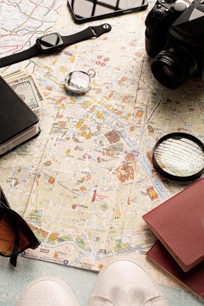 Flat lay traveler accessories on map, camera, glasses, digital devices photo