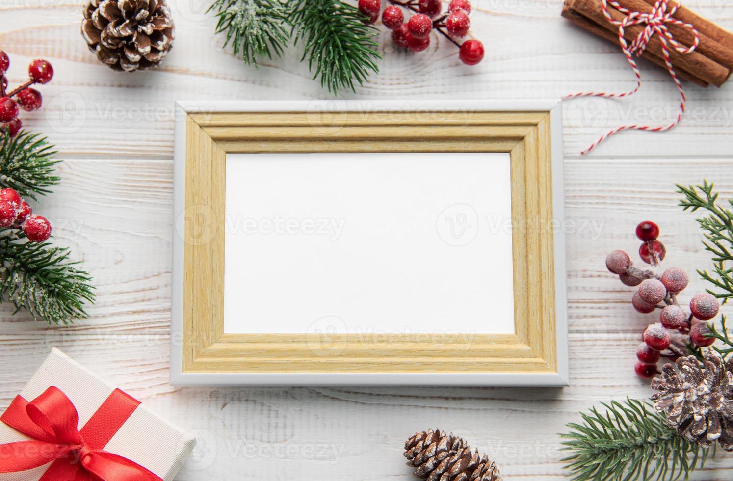 Photo frame,  decorations, fir tree branches on white wooden background