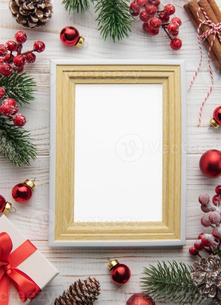 Photo frame,  decorations, fir tree branches on white wooden background