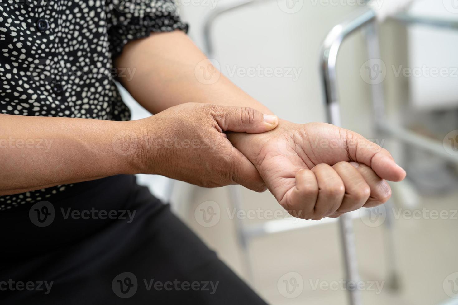 Asian lady woman patient touch and feel pain her elbow and arm, healthy medical concept. photo