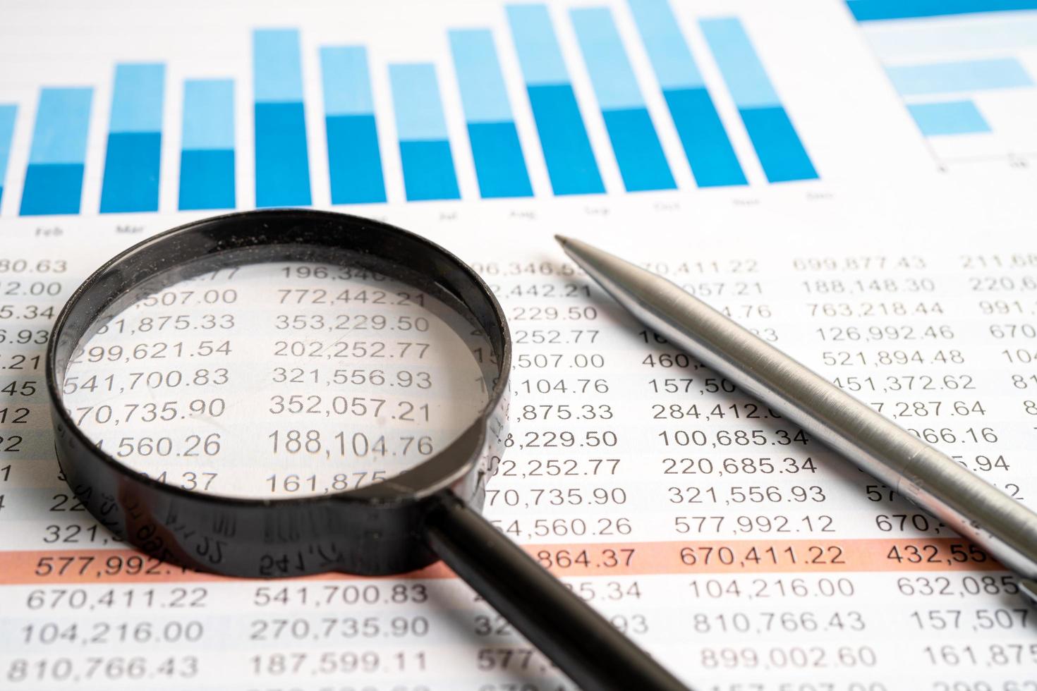 Magnifying glass on charts graphs spreadsheet paper. Financial development, Banking Account, Statistics, Investment Analytic research data economy. photo