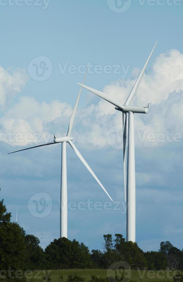 los molinos de viento se alzan contra un cielo nublado azul foto