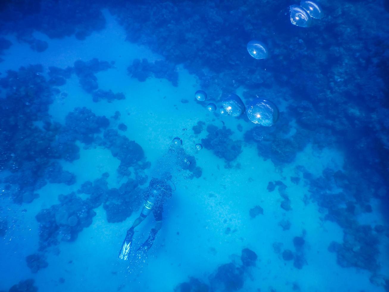 solo buzo con muchas burbujas en el azul profundo del mar foto