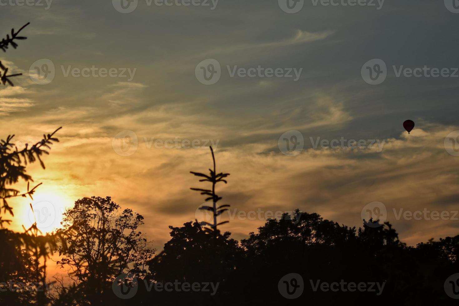 sunset in the summer with a hot air balloon in the sky photo