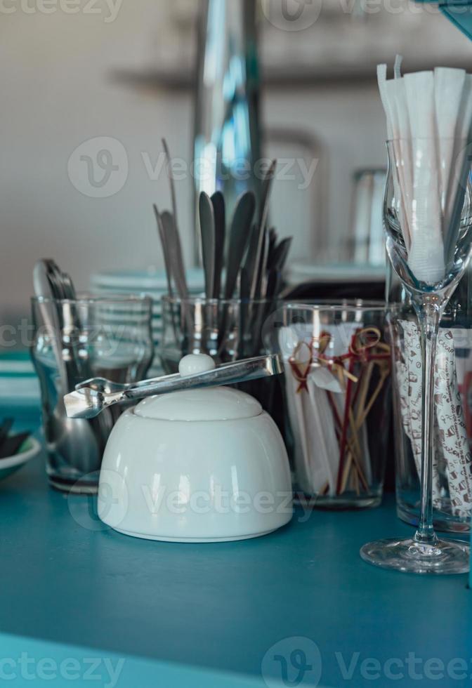 Empty glasses of various shapes and small teapots on the bar counter in a restaurant or cafe. Details of the modern interior in cafe. photo