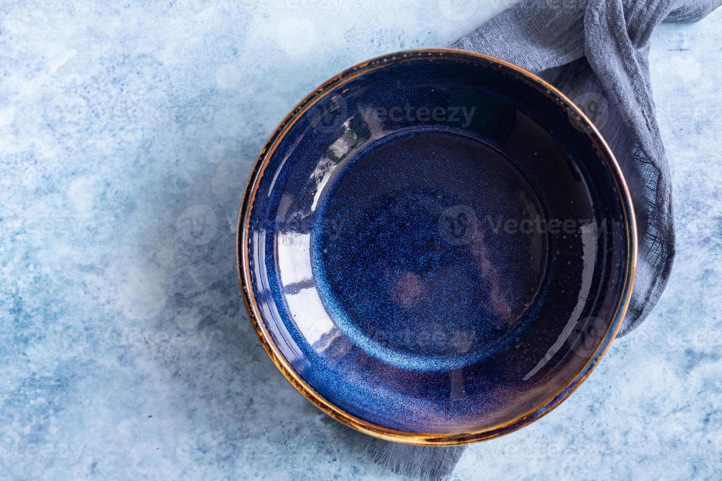 Empty craft blue marble plate and kitchen towel, blue concrete background. Food display menu template. Top view. photo