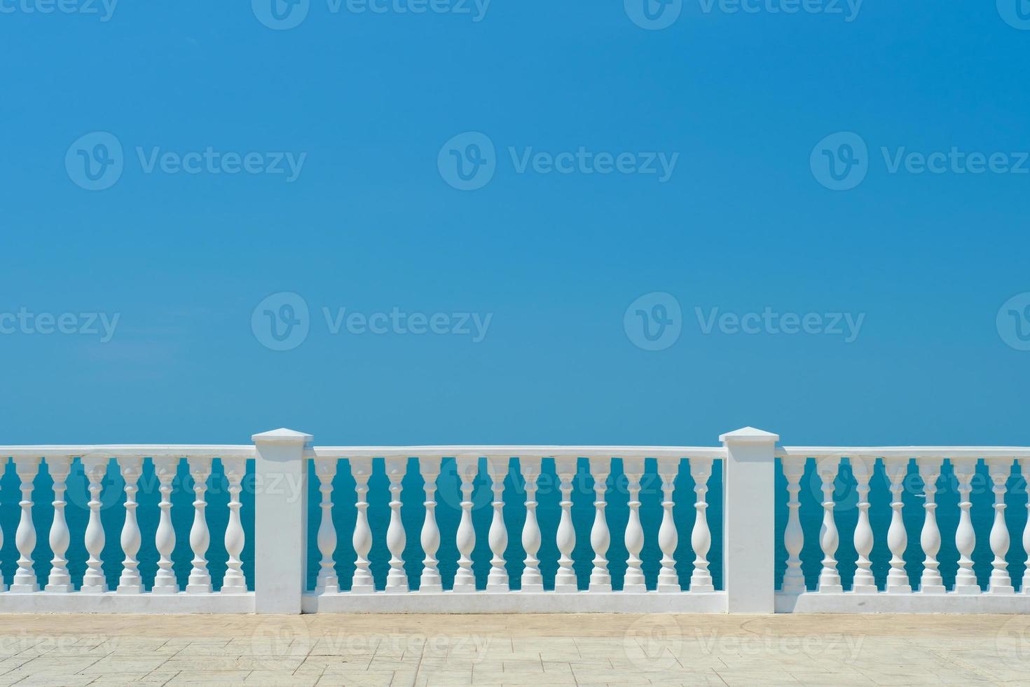 Summer view with classic white balustrade and empty terrace overlooking the mediterranean sea, vacation idea. Free space for text photo