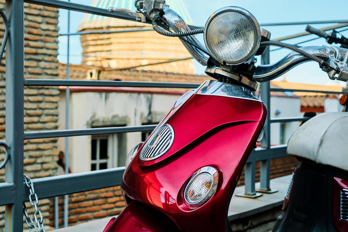 Tbilisi, views of the old city, motor scooter against the background of the old church. Tourism and travel in Georgia. Idea for a screensaver or background photo