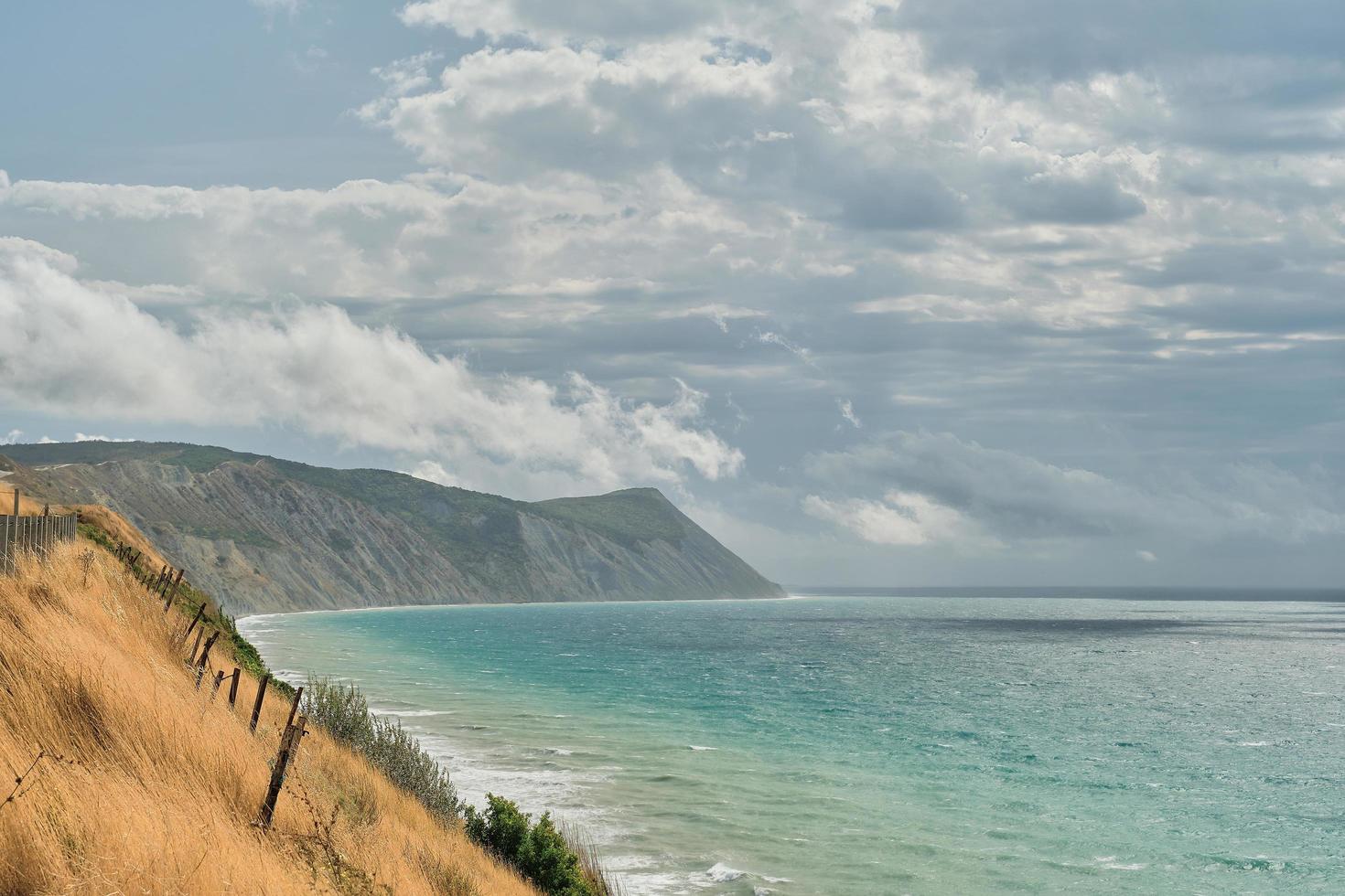 vista desde la orilla alta hasta el mar tormentoso al mediodía, fondo o protector de pantalla para la pantalla. nubes sobre el mar en una tormenta foto