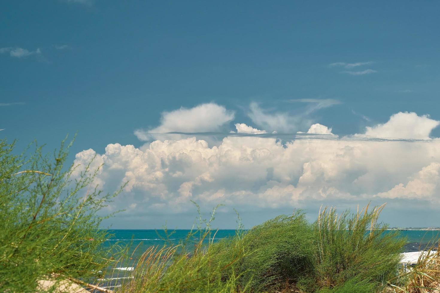 vista desde las dunas de arena hasta el mar y el cielo azul con nubes cumulus, fin de semana de verano, fondo para una pantalla de presentación o papel tapiz para una pantalla o publicidad, espacio libre para texto foto