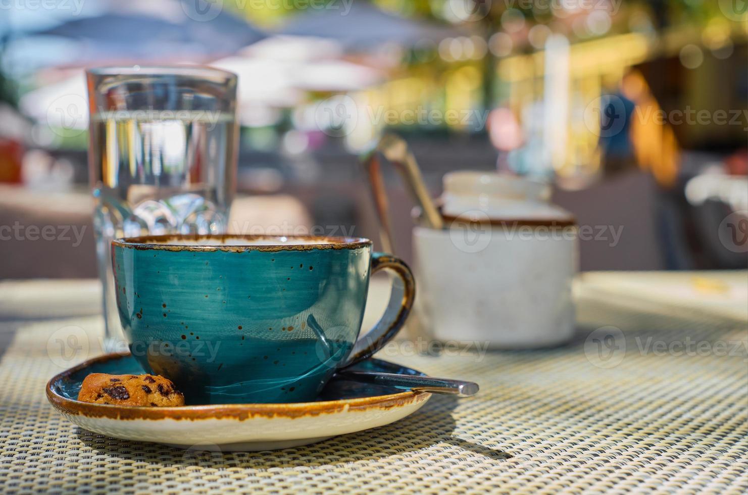 taza de café expreso, un vaso de agua y galletas en la mesa, primer plano, enfoque selectivo, espacio en blanco, desayuno de café, publicidad o pancarta foto