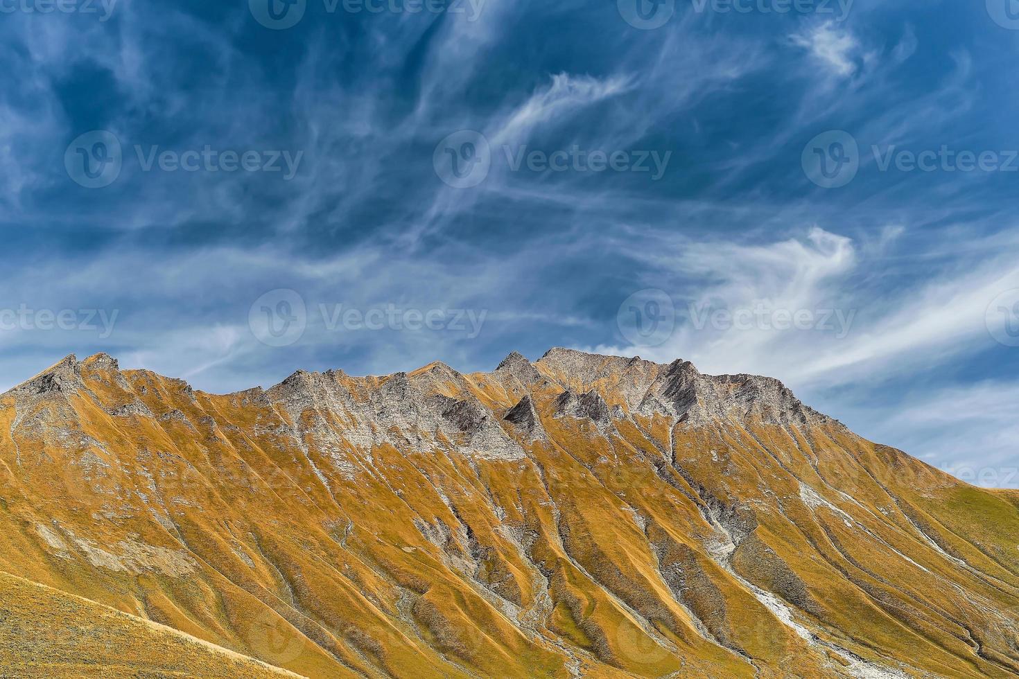 View of the rocky ridge, autumn in the mountains, the sky is covered with clouds. Idea for a banner or postcard with space for text, travel to Georgia, trekking in the mountains photo