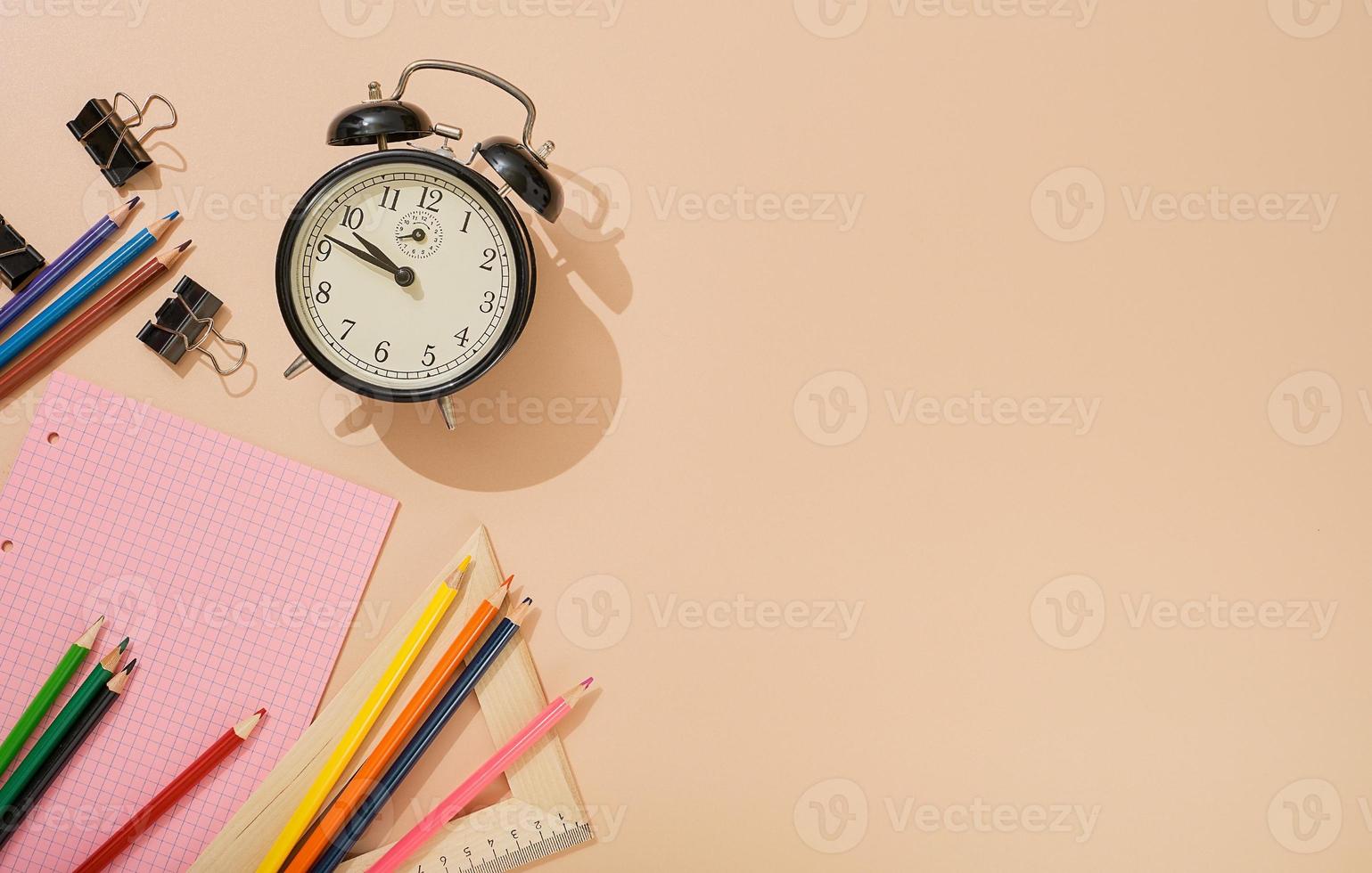 Ready to go back to school, school subjects on a light flesh-colored background. Notepads, pens, pencils, alarm clock and other tools. Banner with place for text. photo