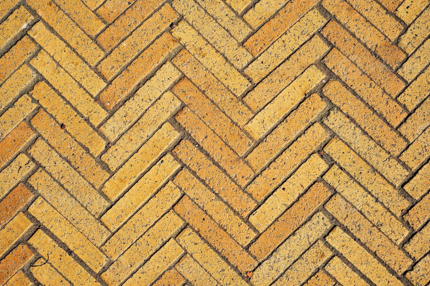 Idea of simple wallpaper for your desktop is pattern with rectangular tiles made of yellow bricks in the form of herringbone. Diagonal texture, abstract background of old brick ceramic cobblestone photo