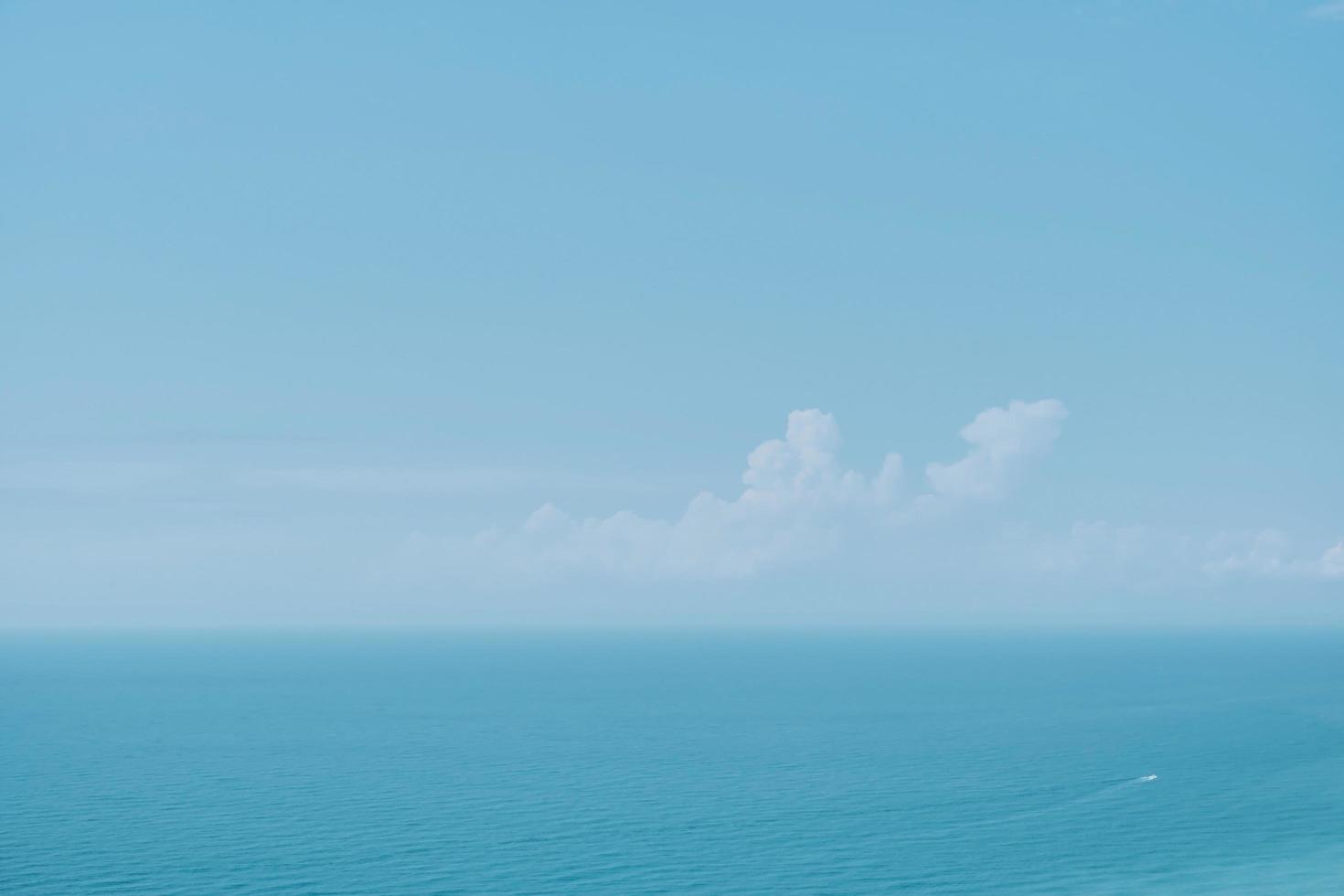 Sunny sky with clouds and a calm sea on a midday background. Soft blurry focus. Hot summer vacation, pastel colors and sun glare. Abstract blur poster or advertising banner photo
