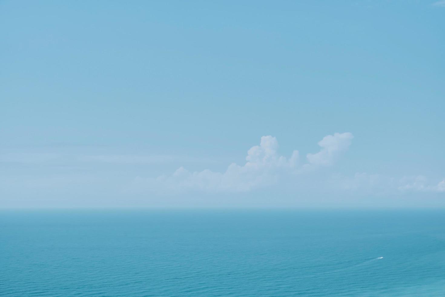 cielo soleado con nubes y un mar en calma sobre un fondo de mediodía. enfoque borroso suave. calurosas vacaciones de verano, colores pastel y resplandor solar. cartel de desenfoque abstracto o banner publicitario foto