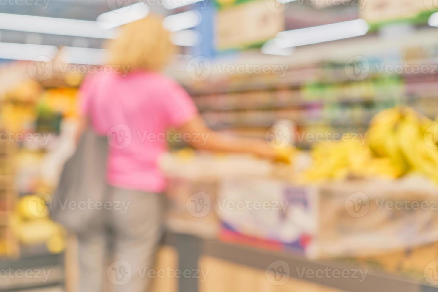 Blurred market background with woman silhouette next to rows of fruit shelves, ready idea for postcard or website design. Mockup for a banner in the office or advertising photo