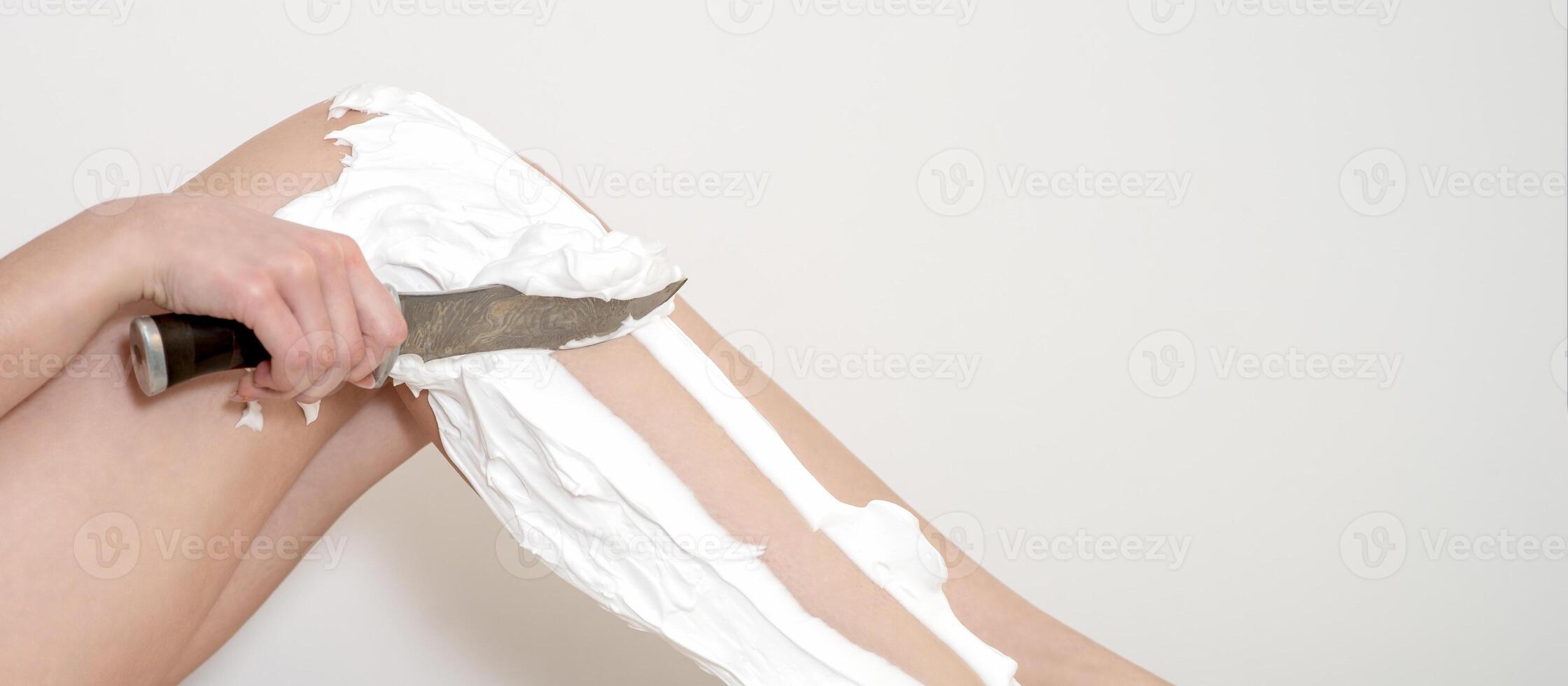 Legs of woman shaving by knife photo