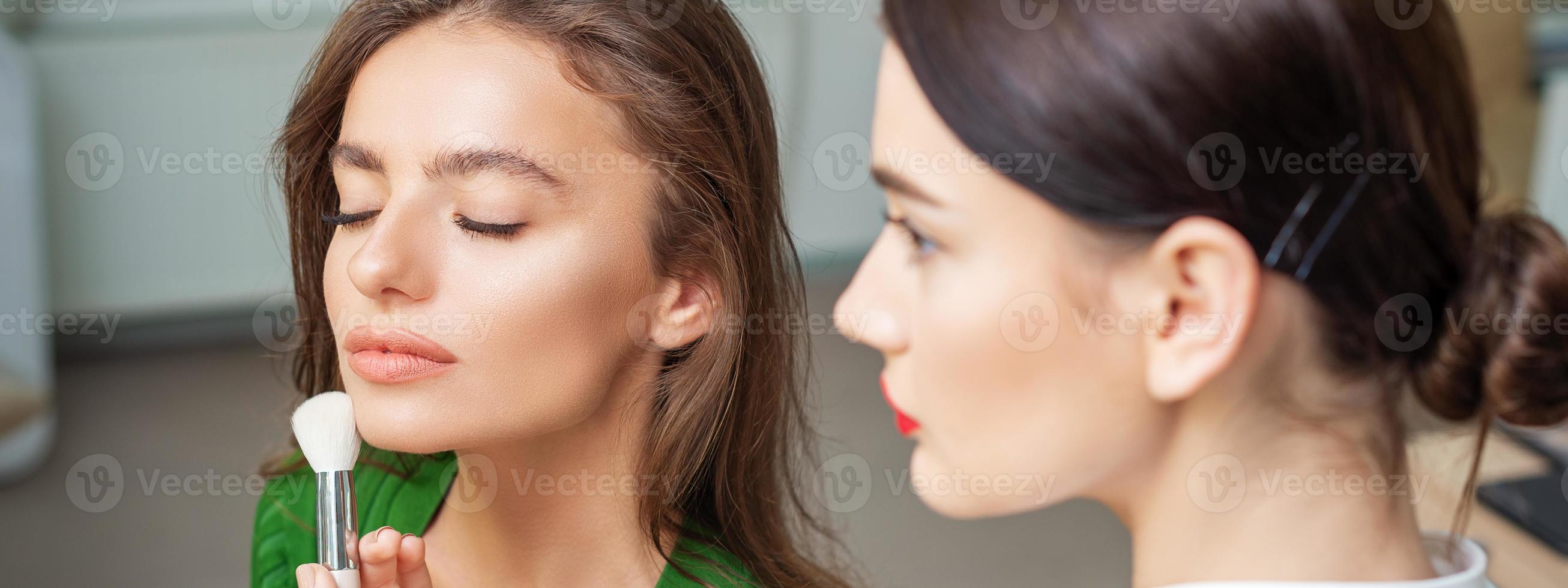 Make up artist applying professional make up of tonal foundation photo