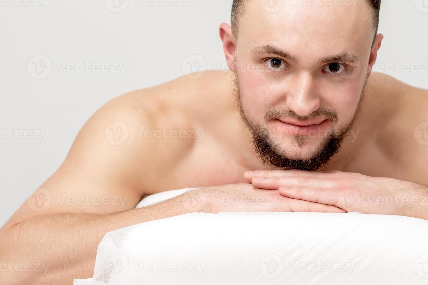 Man lying on front on table spa photo