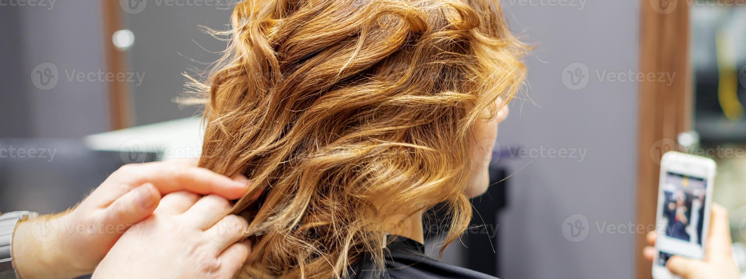 Hairdresser doing hairstyle for young woman photo