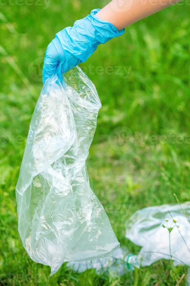 mano de niño limpia el parque de desechos plásticos foto