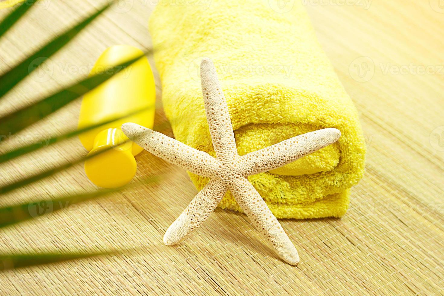 White starfish with yellow wrapped towel on straw sunbed with palm tree. Tourism, travel photo