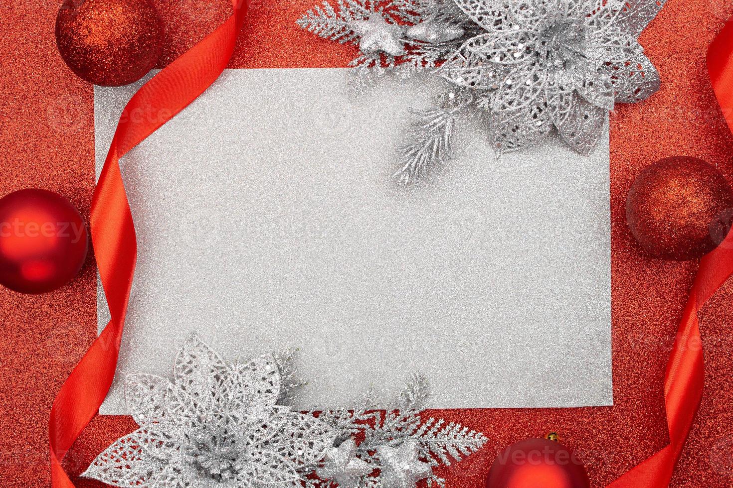 Red Christmas balls with silver branch of flower and ribbons on shiny background. New Year. Top view, flat lay. Copy space photo