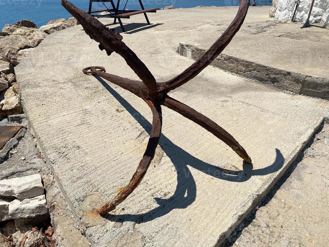 Nautical symbol. Big rusty old anchor out of the water photo