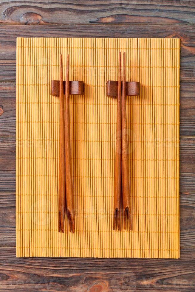 two sets of sushi chopsticks on wooden bamboo background, top view photo