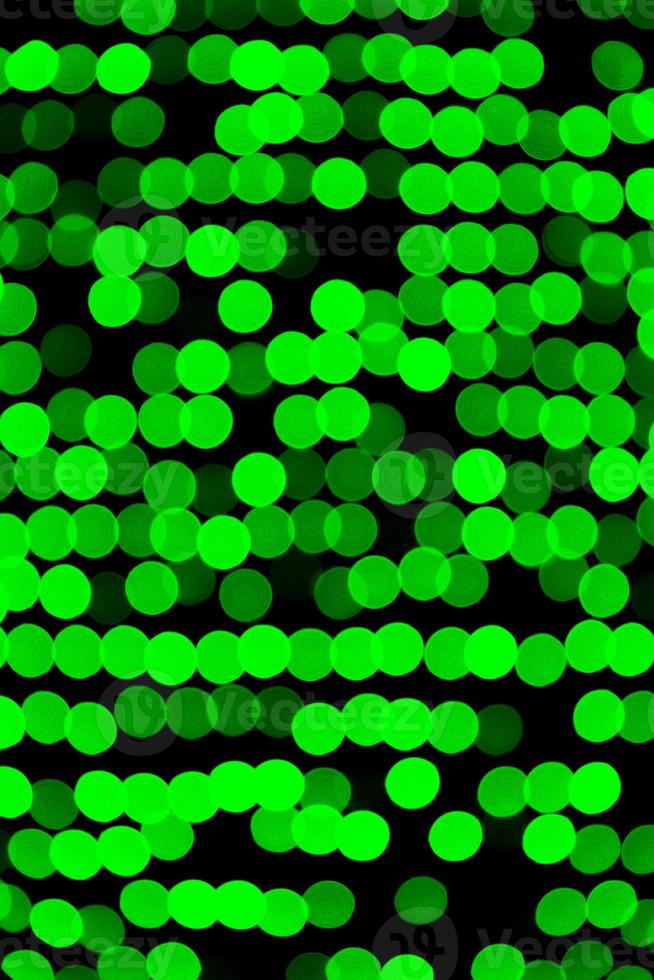 Unfocused abstract green bokeh on black background. defocused and blurred many round light photo