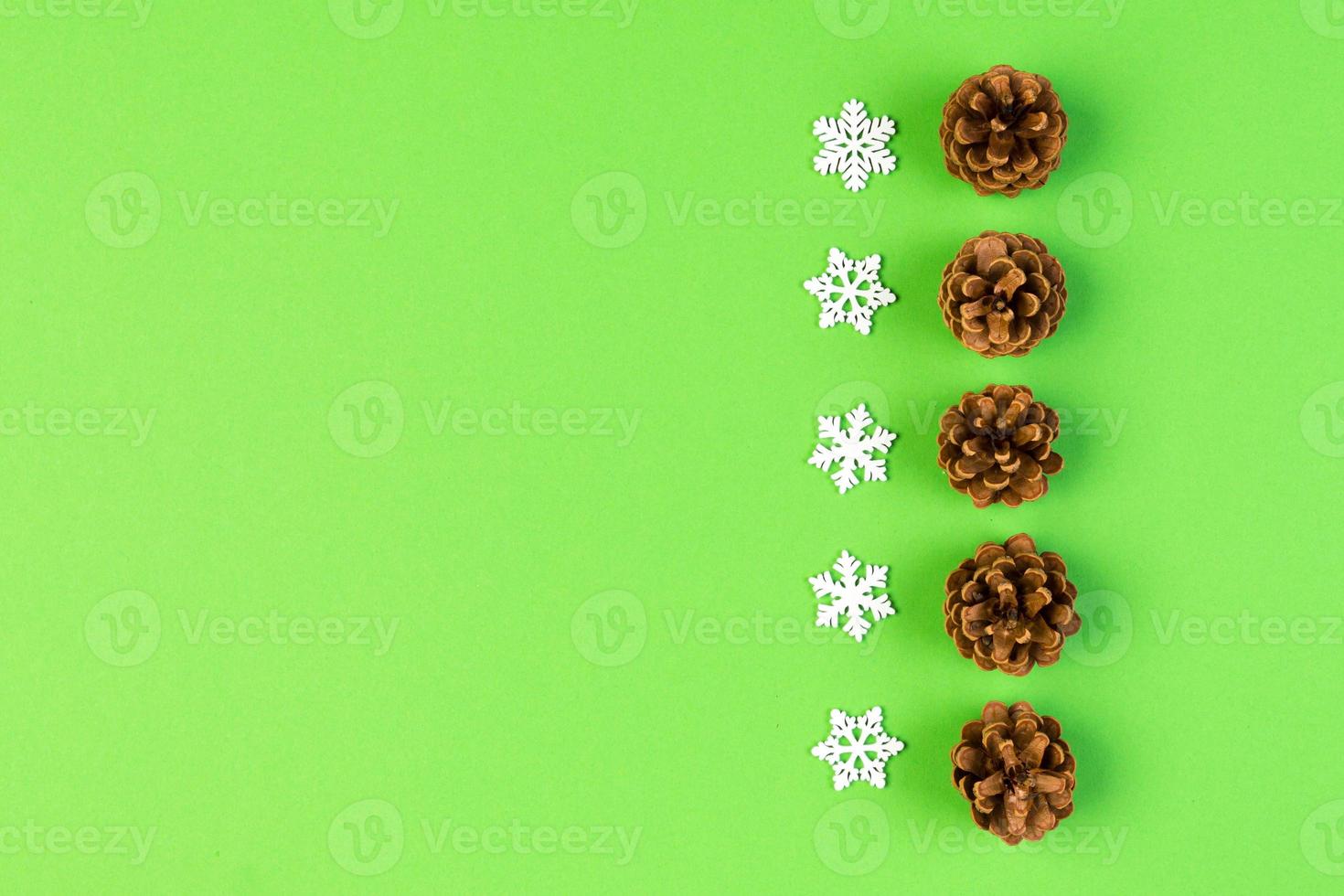 Top view of New Year ornament made of white snowflakes and pine cones on colorful background. Winter holiday concept with empty space for your design photo