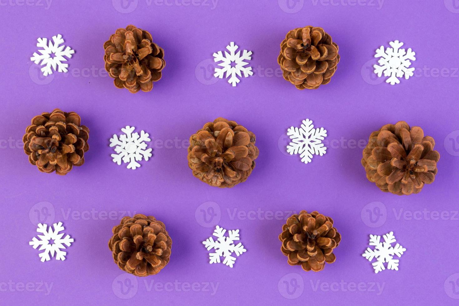 Top view of New Year ornament made of white snowflakes and pine cones on colorful background. Winter holiday concept with empty space for your design photo