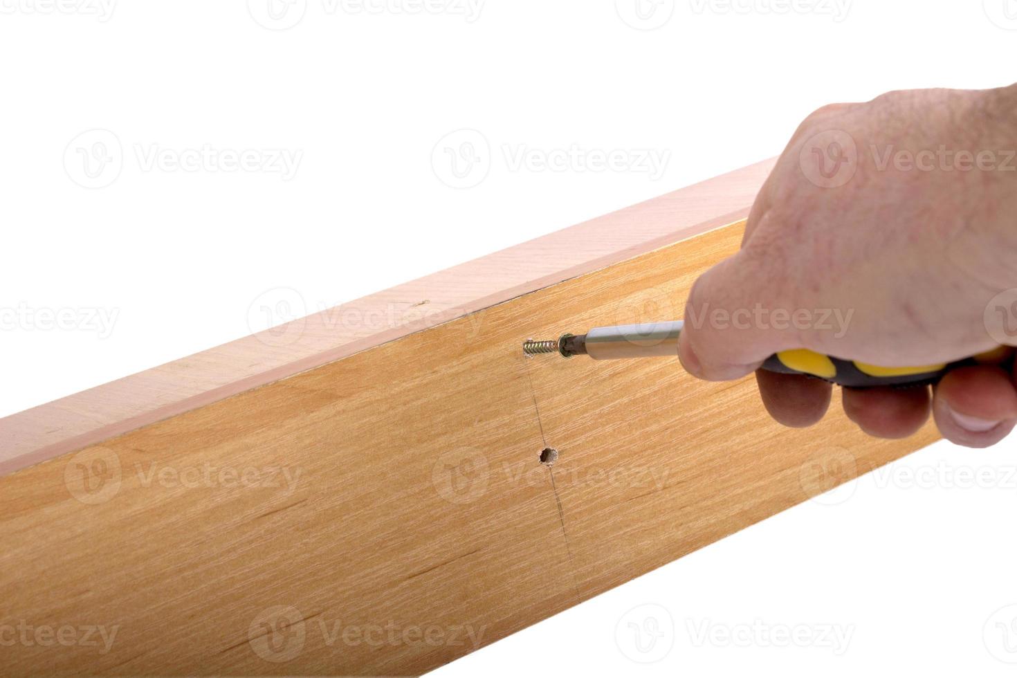 Self-assembly furniture, hand with an Allen key photo