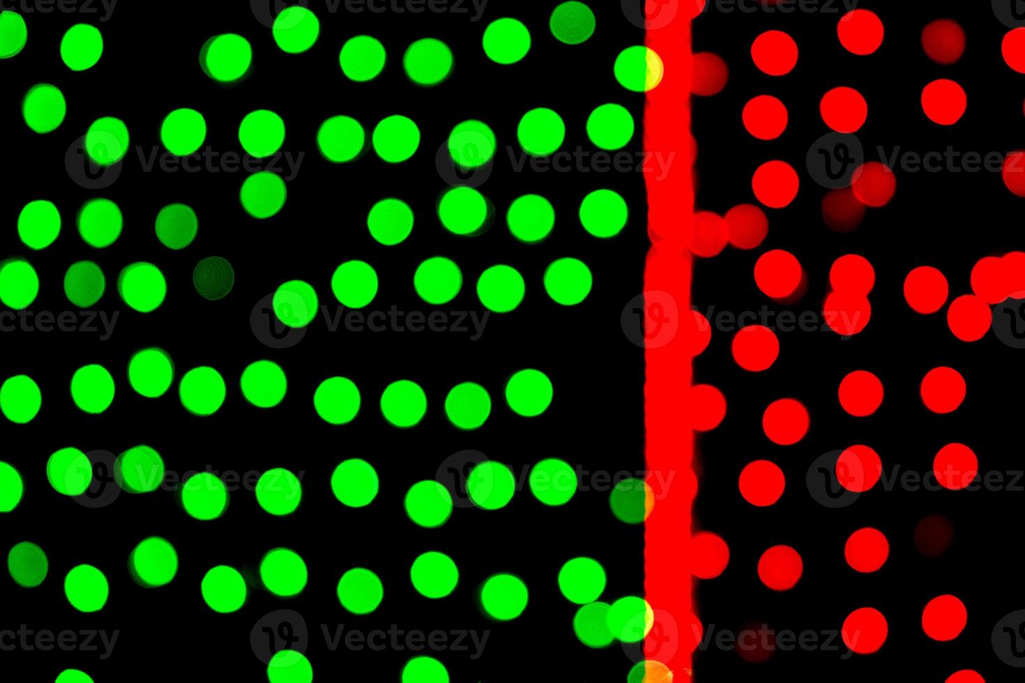 Unfocused abstract green and red bokeh on black background. defocused and blurred many round light photo