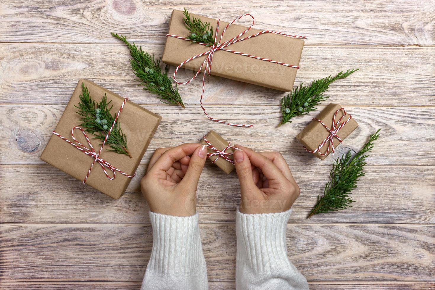 Hands of woman decorating Christmas gift box photo