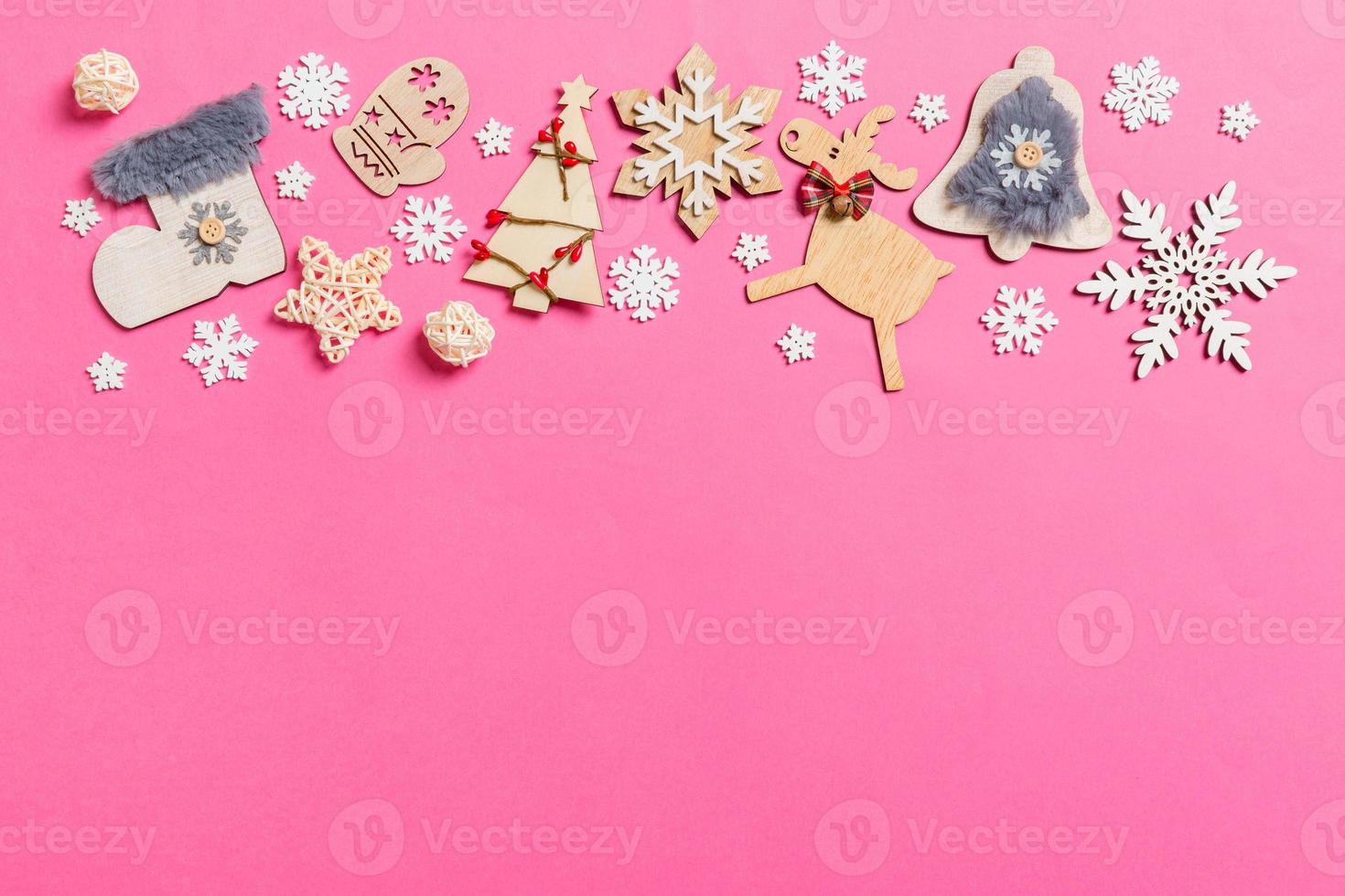 Top view of holiday decorations and toys on pink background. Christmas ornament concept with empty space for your design photo