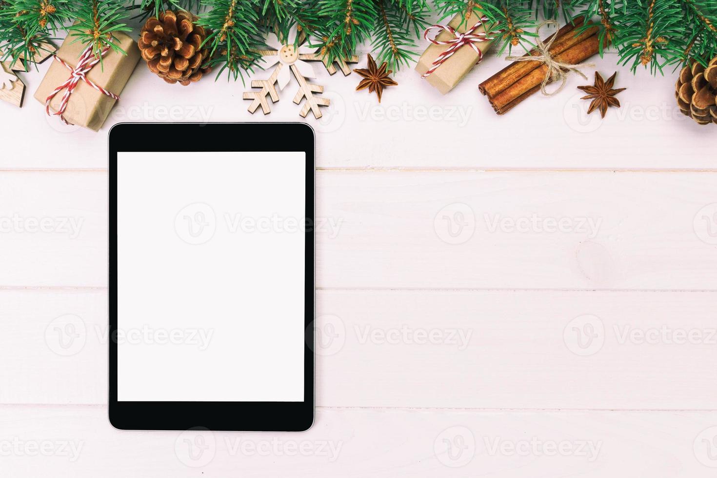 Digital tablet mock up with rustic Christmas wooden background decorations for app presentation. top view with copy space. Toned photo