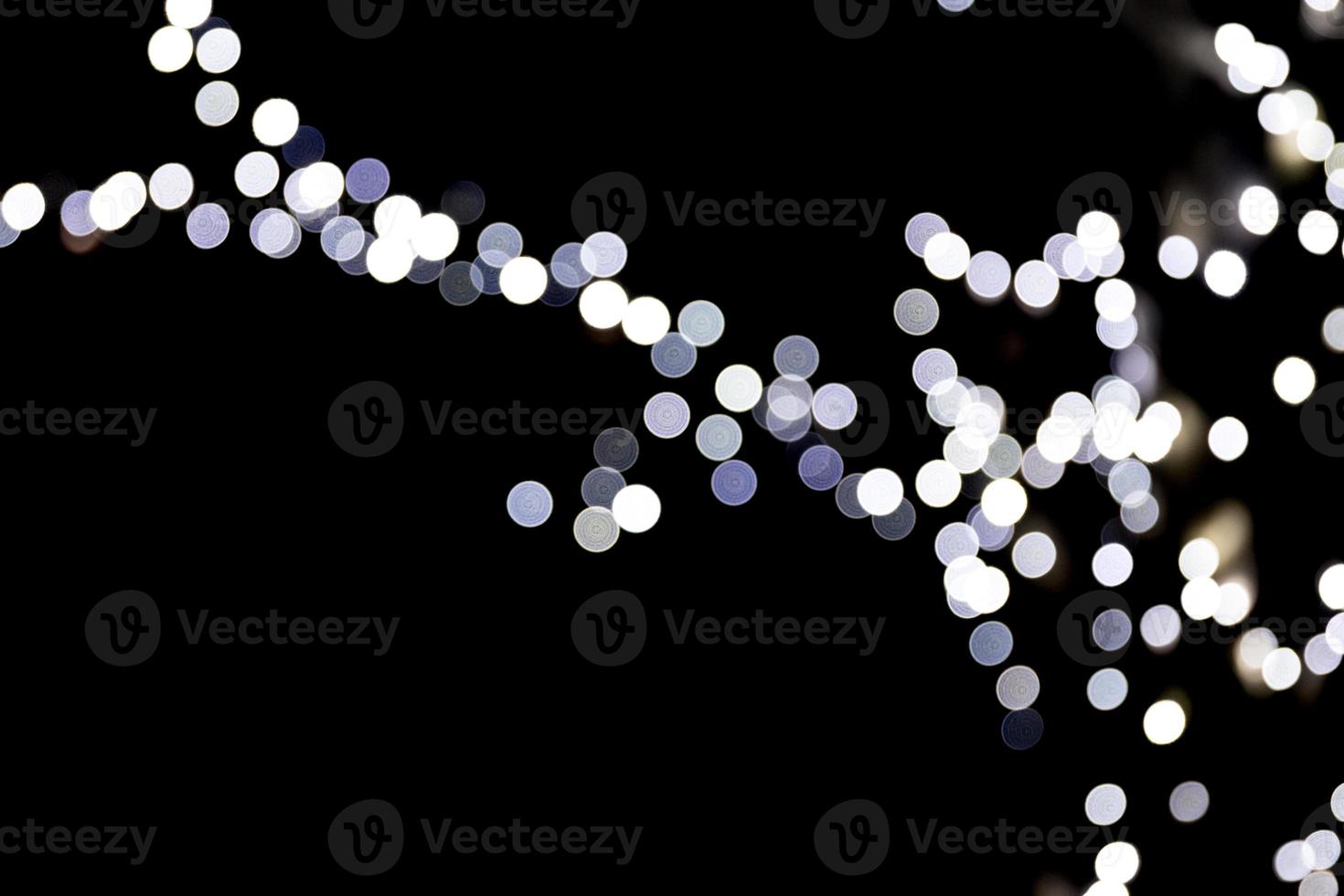 Unfocused abstract white bokeh on black background. defocused and blurred many round light photo