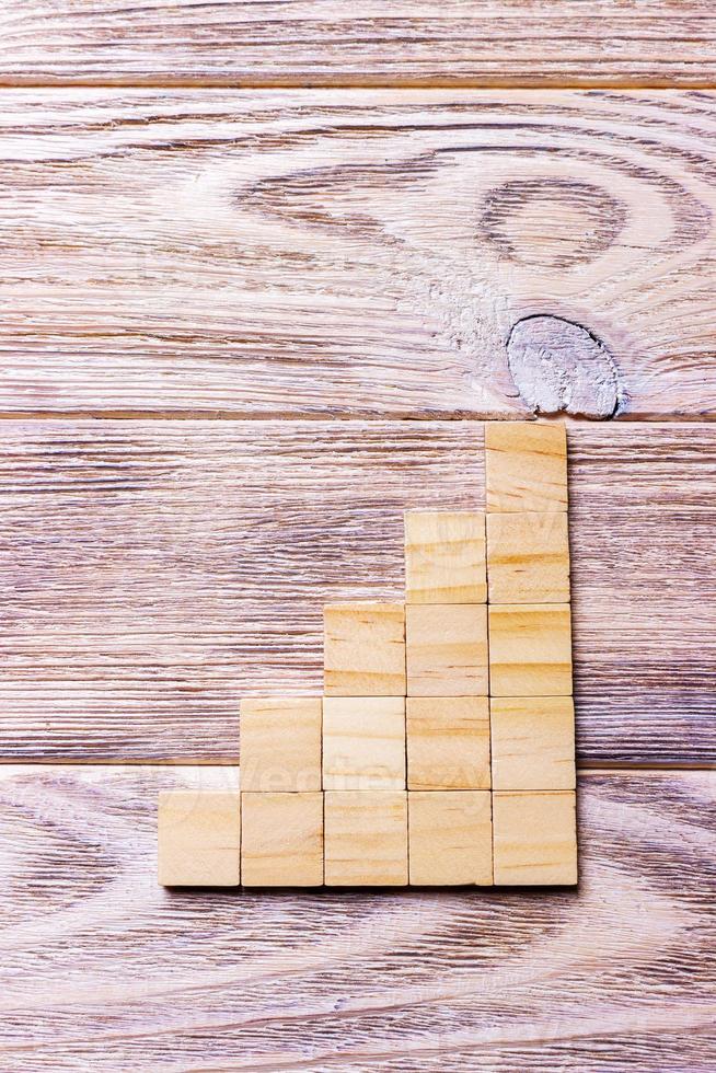A wooden blocks cube over black wooden textured background with copy space for add word text title. Concept or conceptual Wood block stair or five steps. Cubic photo