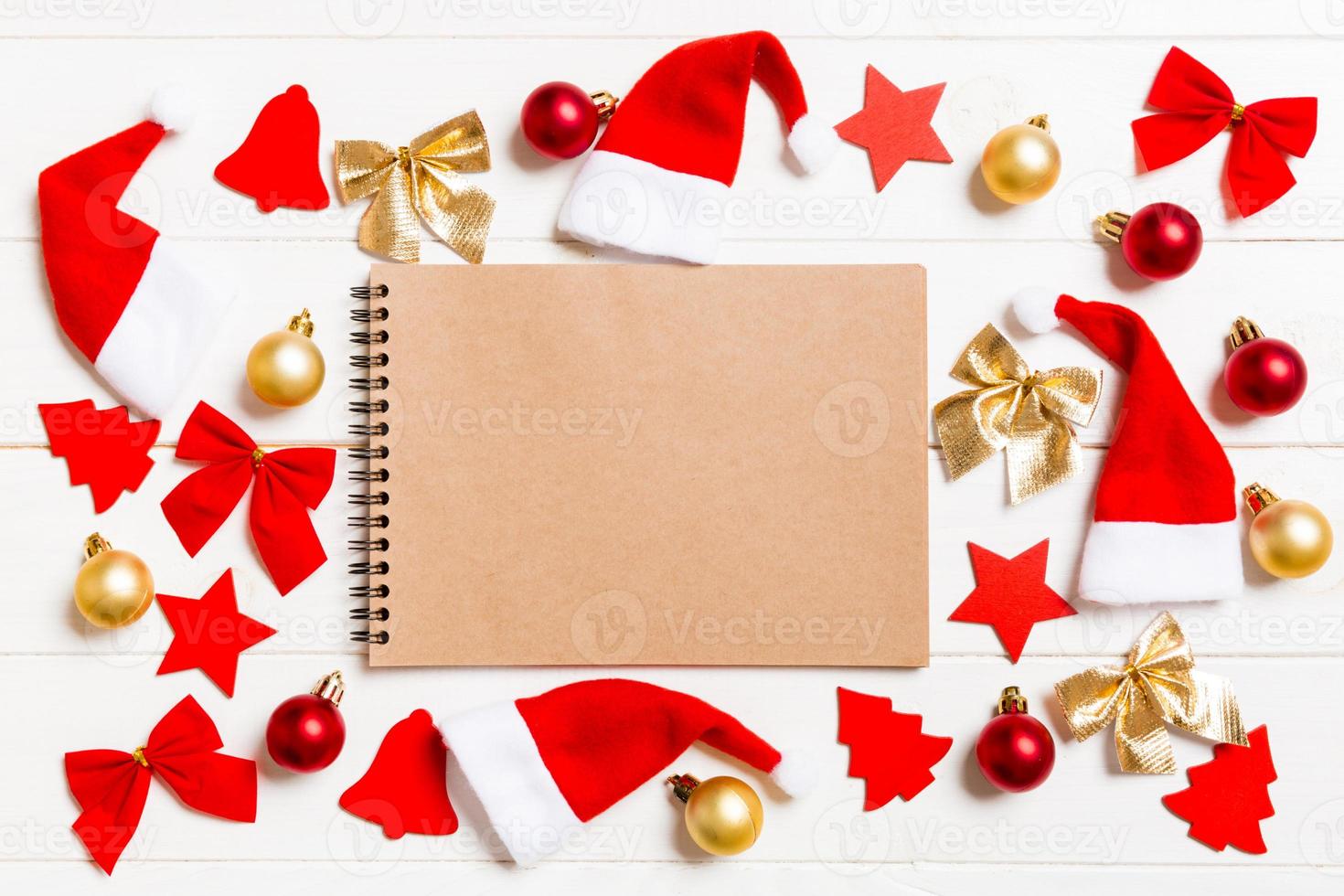 Top view of notebook on wooden background made of Christmas decorations. New Year concept photo
