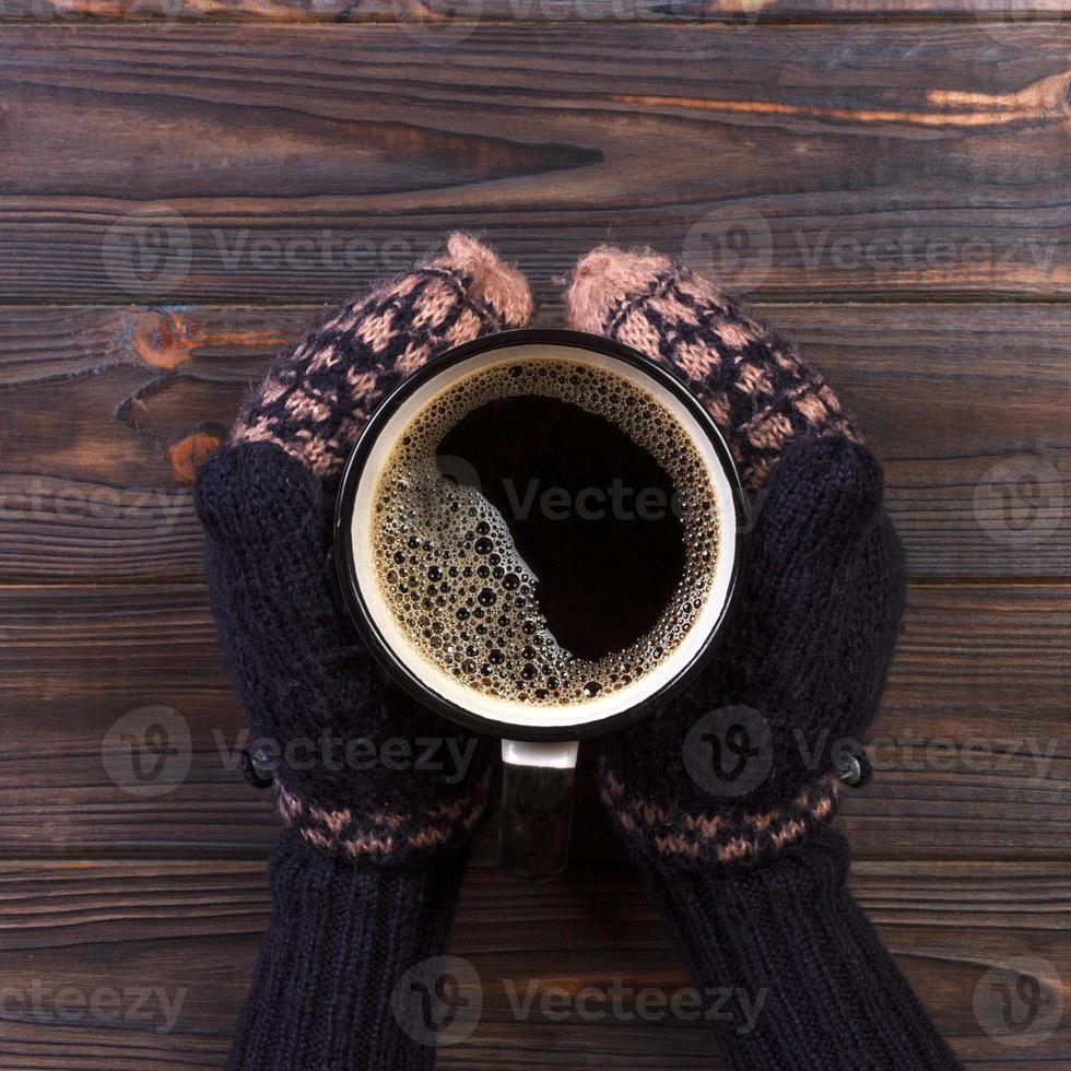 Girl in a warm clothes and mittens is holding white mug in hands. Mockup for winter gifts design, Merry Christmas and Happy New Year photo