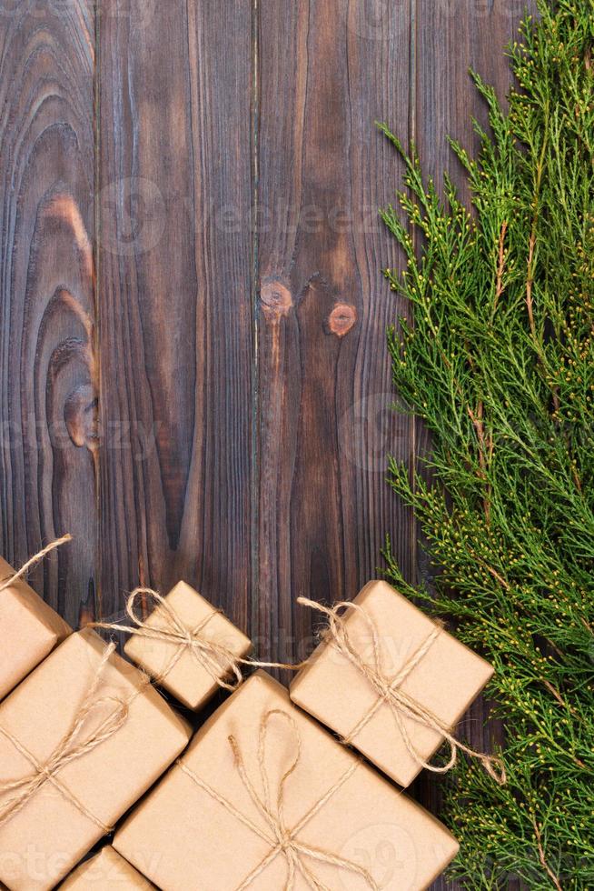 ramas de abeto de navidad con caja de regalo sobre fondo de madera rústica oscura con espacio para copiar texto foto