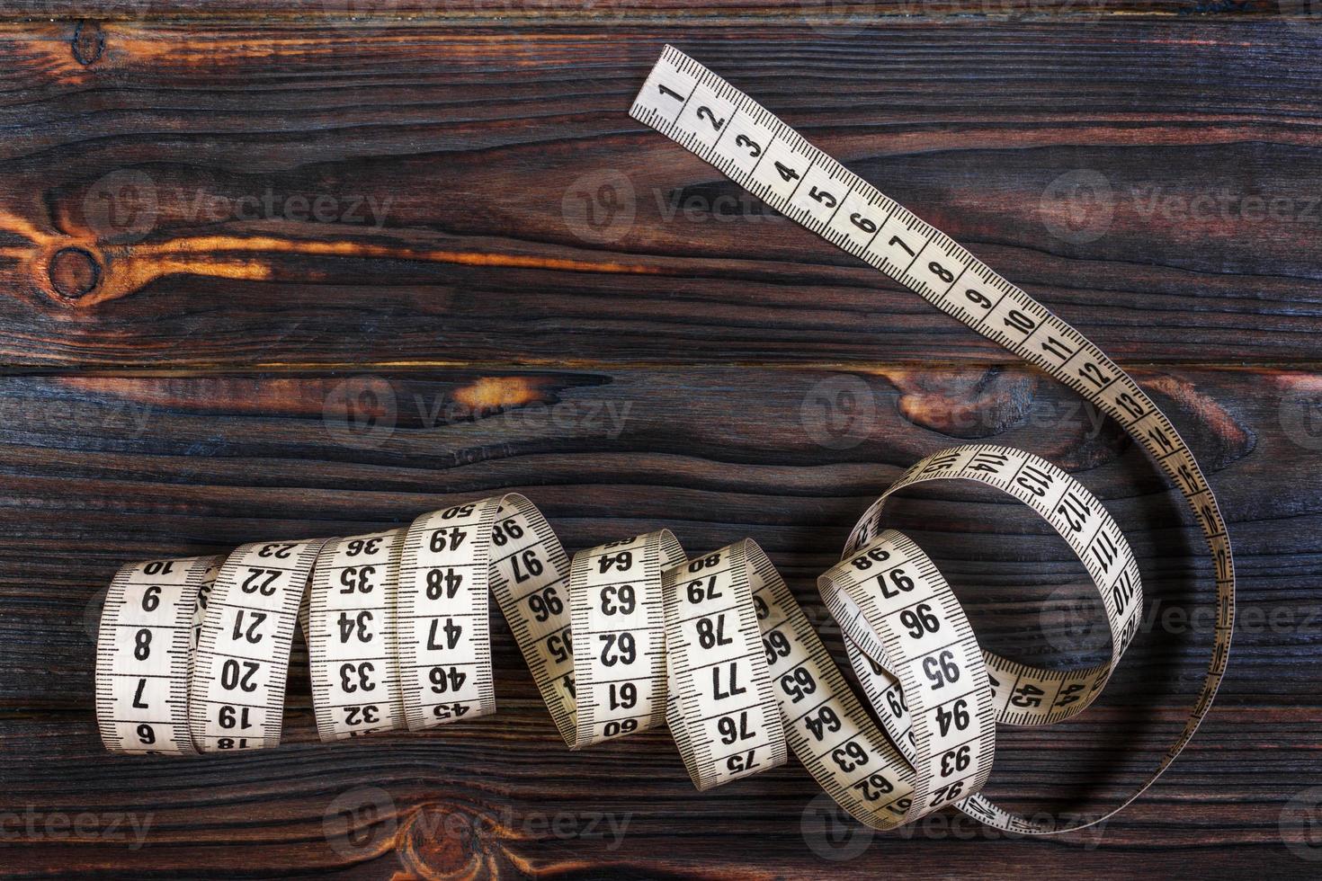 Tailoring Meter White measuring tape on wooden background photo