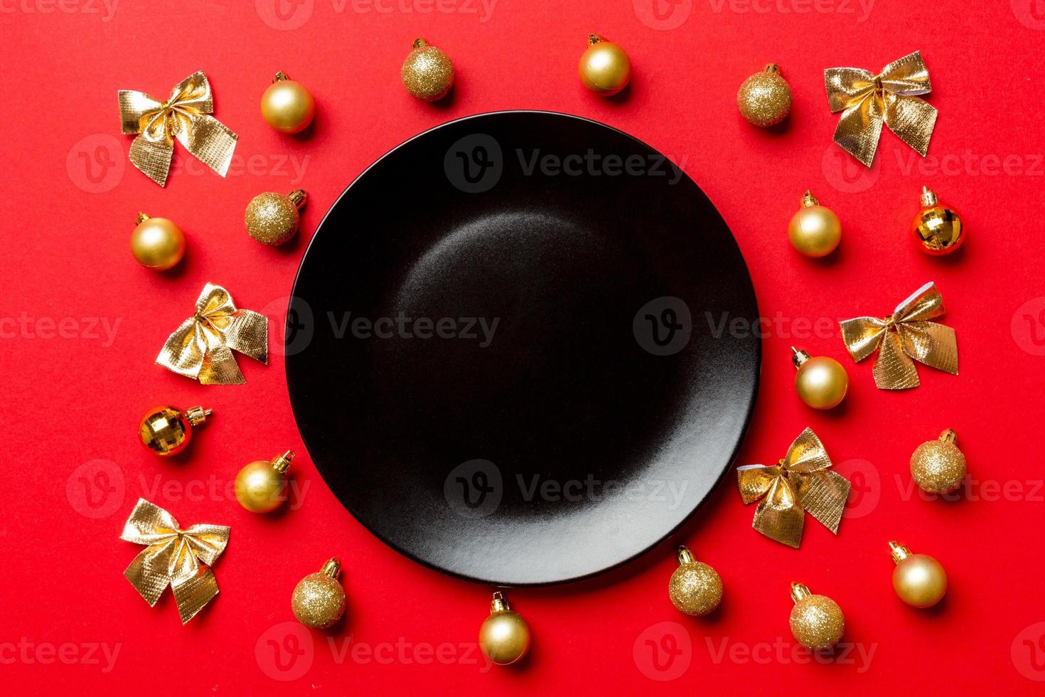 Top view of holiday dinner on colorful background. Plate, baubles and bows. Christmas Eve concept photo
